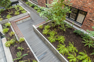 courtyard garden with benches and wooden walkway - Powered by Adobe