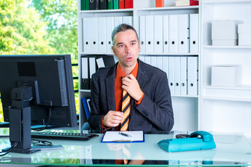 business man behind his desk in summerly hot office