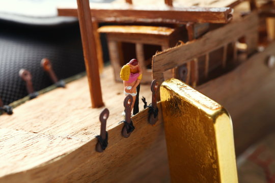 Gold bar put beside miniature scratch build junk ship wooden model in the scene see the figure couple model also.