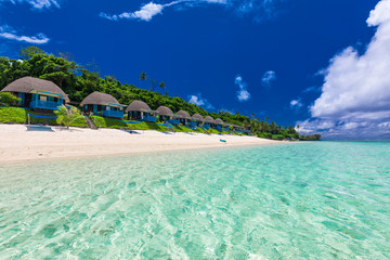 Tropical beach with with palm trees and villas, Polynesia