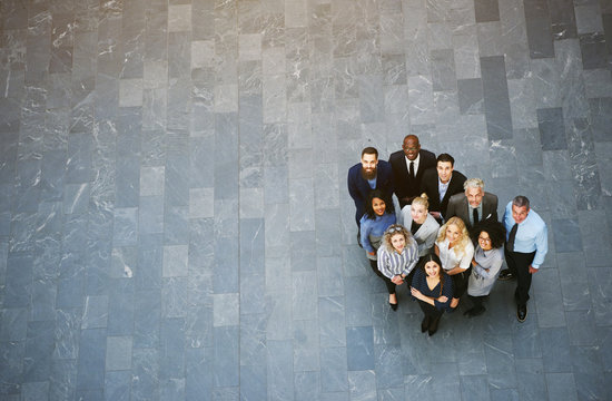 Multiracial business people standing in office hall and looking up