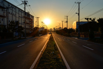 夕日に向かって真っ直ぐ伸びる日本の道路