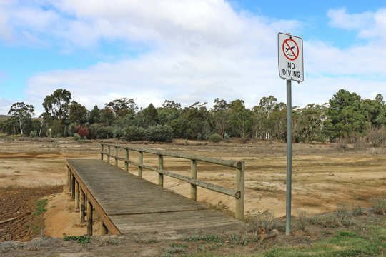 No Diving sign and wooden pier at dried out lake bed
