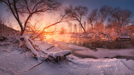 Panoramic russian winter landscape with forest, beautiful frozen river at sunset. Scenery with winter trees, water and blue sky at twilight. Frosty snowy river. Snow. Reflection in water. - 154210979