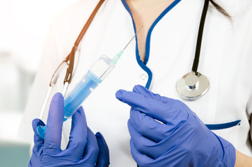 Woman doctor with gloves holding medical injection syringe