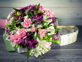 Wedding bouquet. Carnation, eustoma. Gift box in the form of heart. Background of old tree. Selective focus.