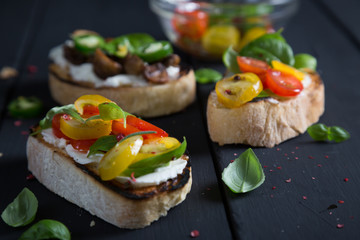 Bruschetta with cherry tomatoes, cream cheese, mushrooms, basil