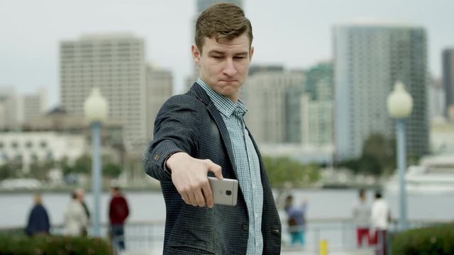 Young man is taking a selfie on a street