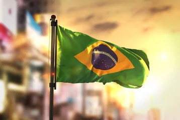 Fotobehang Brazilië Vlag van Brazilië tegen stad wazig achtergrond bij zonsopgang Backlight