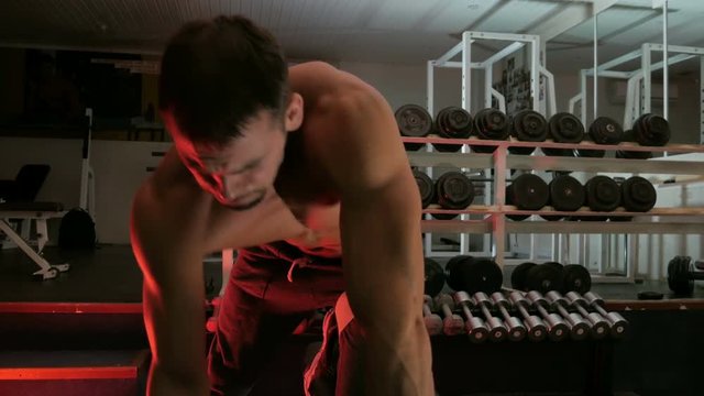 body-builder shakes his arm muscles
