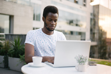 Handsome Afro American businessman in casual clothes with laptop
