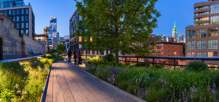 Highline panoramic view at twilight with city lights, illuminated skyscrapers and high-rises. Chelsea, Manhattan, New York City