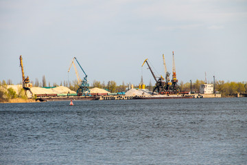 Fototapeta premium Harbor cranes at cargo port on the river Dnieper in Kremenchug, Ukraine
