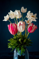 Bouquet of tulips and white anemones flowers on dark blue background