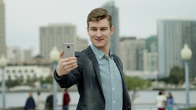 Young handsome is taking a few pictures of himself