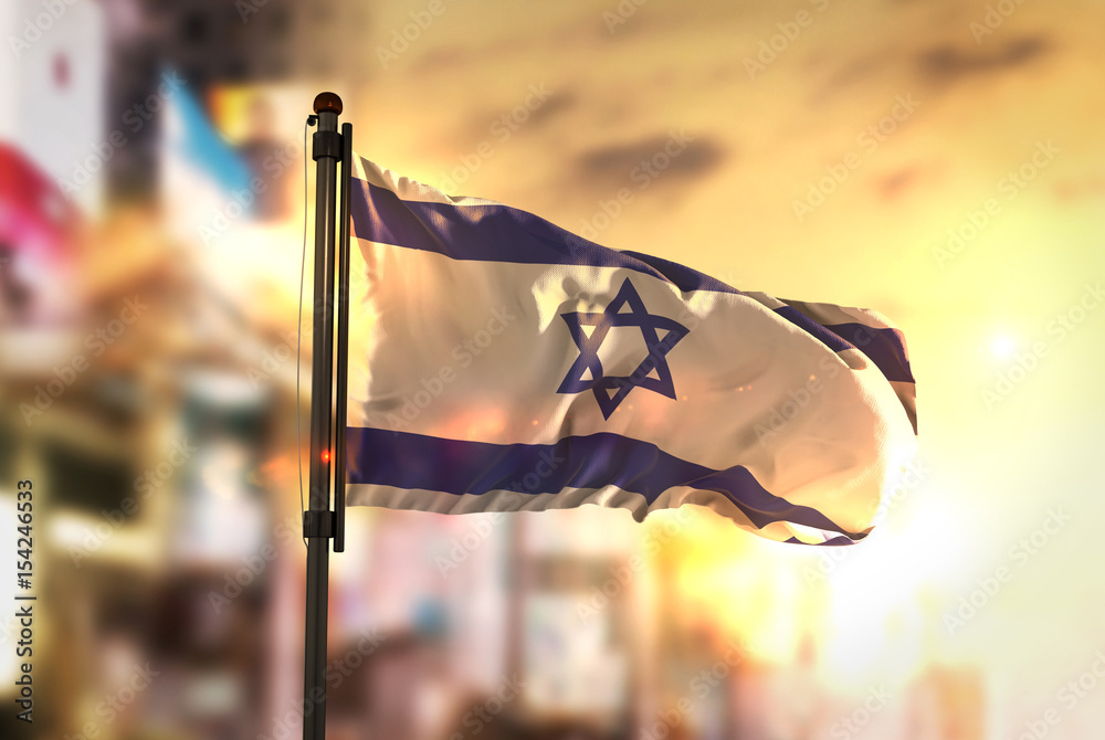 Wall mural Israel Flag Against City Blurred Background At Sunrise Backlight