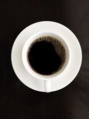 top view of black coffee in a cup of coffee on black background