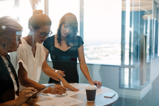 Businesswomen standing at the table and discussing new strategie
