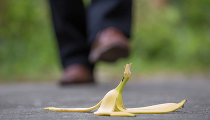 eine Bananenhaut liegt auf dem Gehweg, ein Mann läuft direkt darauf zu