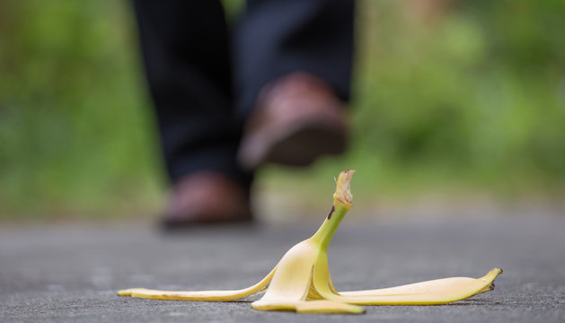 eine Bananenhaut liegt auf dem Gehweg, ein Mann l&auml;uft direkt darauf zu
