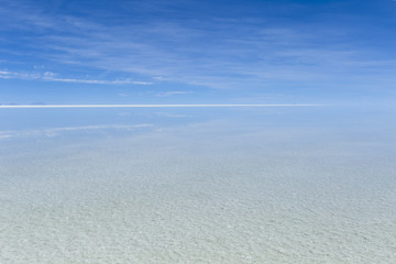 White horizon line and clouds reflection at Uyuni salt flats in Bolivia.