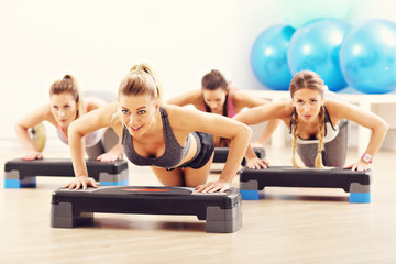 Group of smiling people doing push-ups
