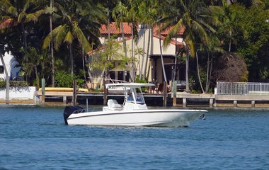 Fototapeta na wymiar Small white fishing boat cruising by Dilido Island on Miami Beach.