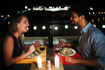 Beautiful couple in love having romantic dinner at night