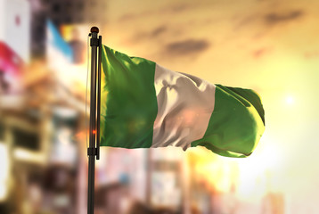 Nigeria Flag Against City Blurred Background At Sunrise Backlight - obrazy, fototapety, plakaty