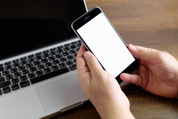 blank screen smartphone in hand with laptop blurred concept for smart life, internet of thing, IOT, digital connecting, online