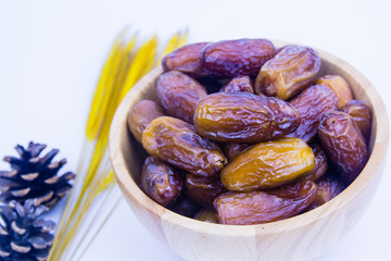 Close up of a plate of dried dates on a wooden background.