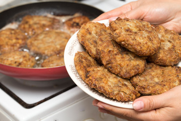 Fried chicken in a frying pan in hand