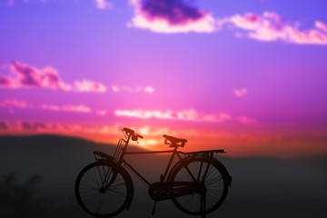 Naklejka na ściany i meble silhouette of bicycle with blurred background sunset