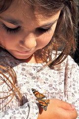 Kleines Mädchen mit Schmetterling auf der Hand