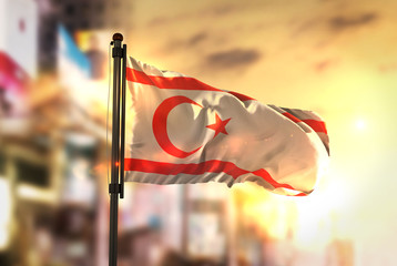 Northern Cyprus Flag Against City Blurred Background At Sunrise Backlight