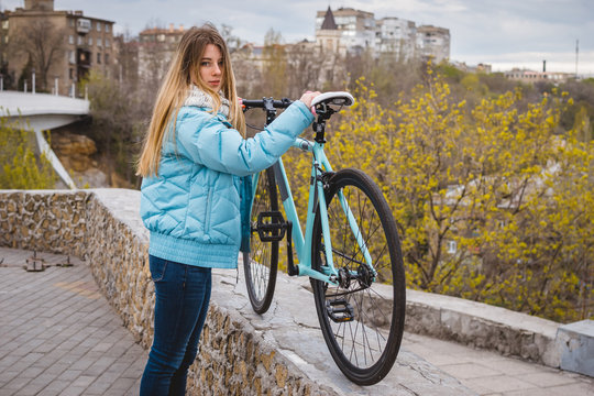 Young hipster girl standing with fixed gear bike at city centre