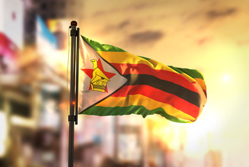 Zimbabwe Flag Against City Blurred Background At Sunrise Backlight - obrazy, fototapety, plakaty