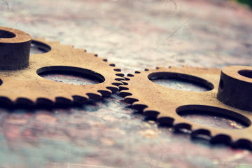 Filtered picture of cogwheels on a colorful wooden background