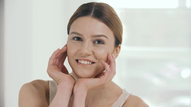 Female Skincare. Beautiful Smiling Woman Holding Hands Near Head