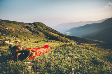 Man relaxing in sleeping bag enjoying sunset mountains landscape Travel Lifestyle camping concept...