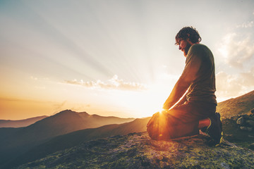 Man relaxing at sunset mountains Travel Lifestyle spiritual emotional meditating concept vacations...