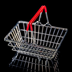 concept of black friday advert sale empty metal shopping basket  isolated on black background, close up