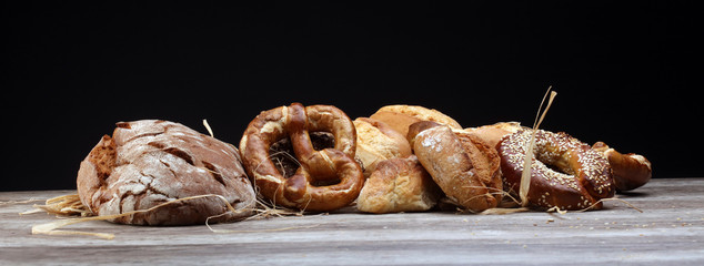 Different kinds of bread and bread rolls on board from above. Kitchen or bakery poster design.