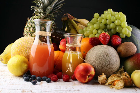 Apple and orange juice -several bottles with fruit and berry juices, vintage wooden background, selective focus