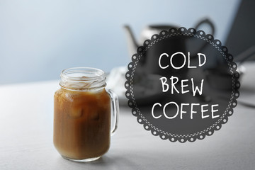 Iced coffee in glass jar on white wooden table
