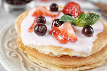 Delicious pancakes with berries and yogurt on plate