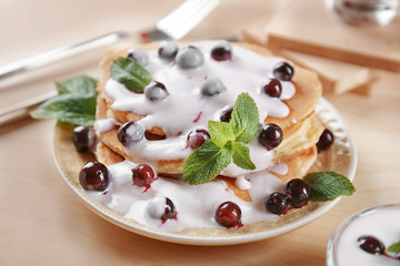 Delicious pancakes with berries and yogurt on plate