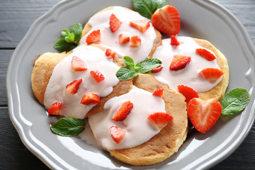Delicious pancakes with strawberry and yogurt on plate
