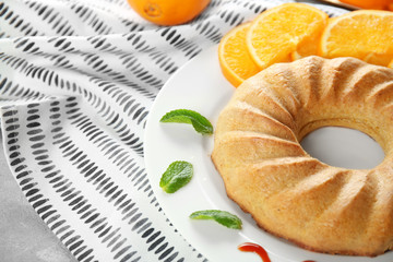 Plate with appetizing citrus cake and orange slices, close up