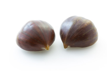 Two tasty uncooked chestnuts with white background